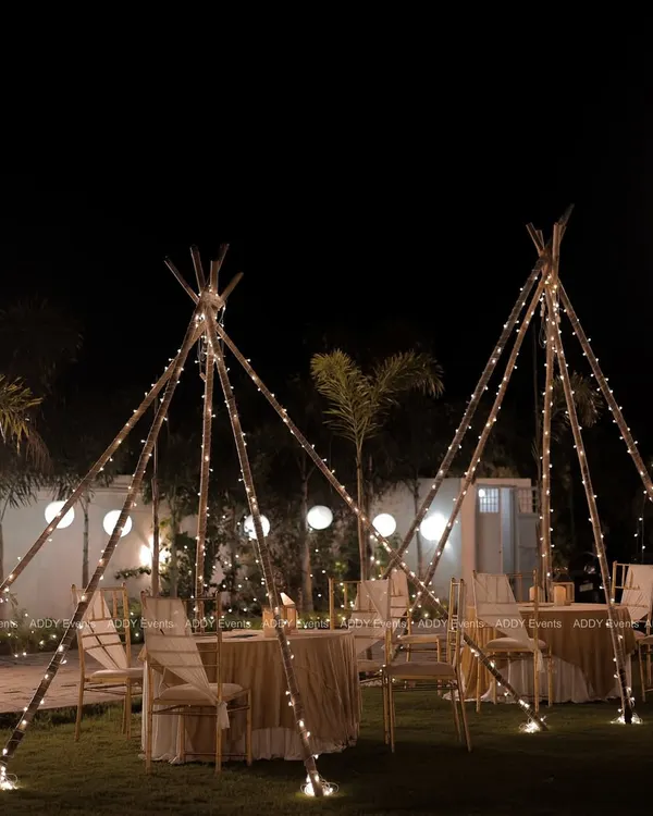 A magical outdoor dining experience. We created these enchanting teepee-style structures, wrapped in fairy lights, to provide a cozy and intimate setting for guests to dine under the stars.