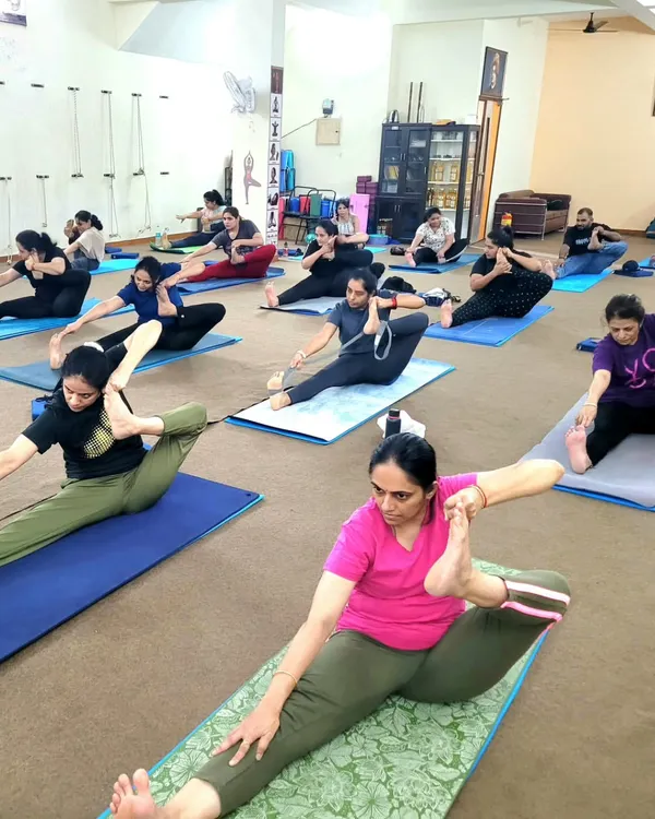 A group of students practicing a seated forward bend variation during a teacher training session. We emphasize synchronized practice to build a collective energy in the class.