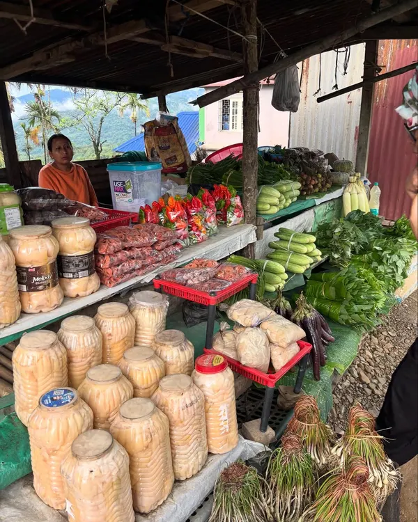 A glimpse into a farmers' market in Nagaland, where we source many of our ingredients. You can see jars of fermented bamboo shoot, fresh Raja Mircha, and local greens being sold by the women who grow them.