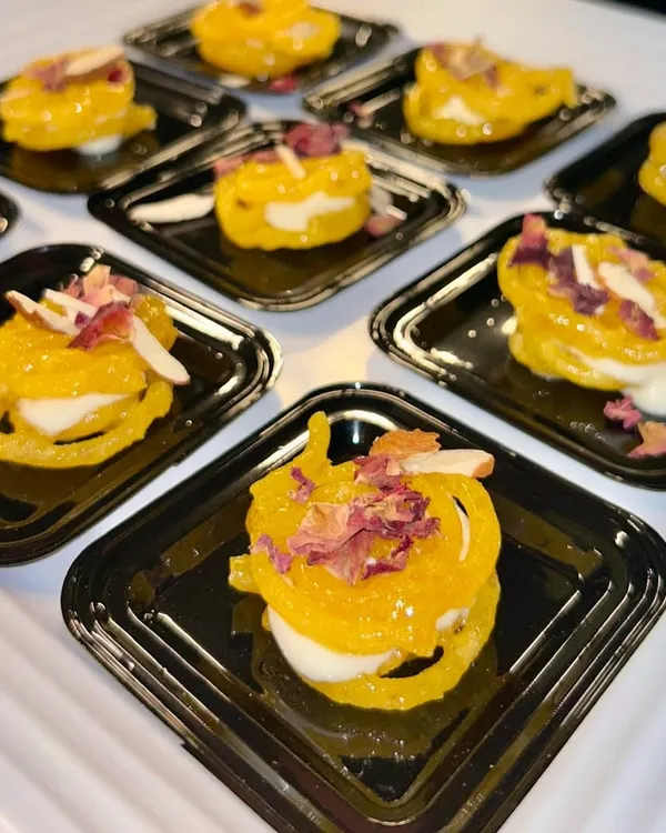 My Rabdi Jalebi is a heavenly fusion of two classics. A crispy, syrup-soaked jalebi is filled with rich and creamy rabdi, then garnished with almonds and rose petals.