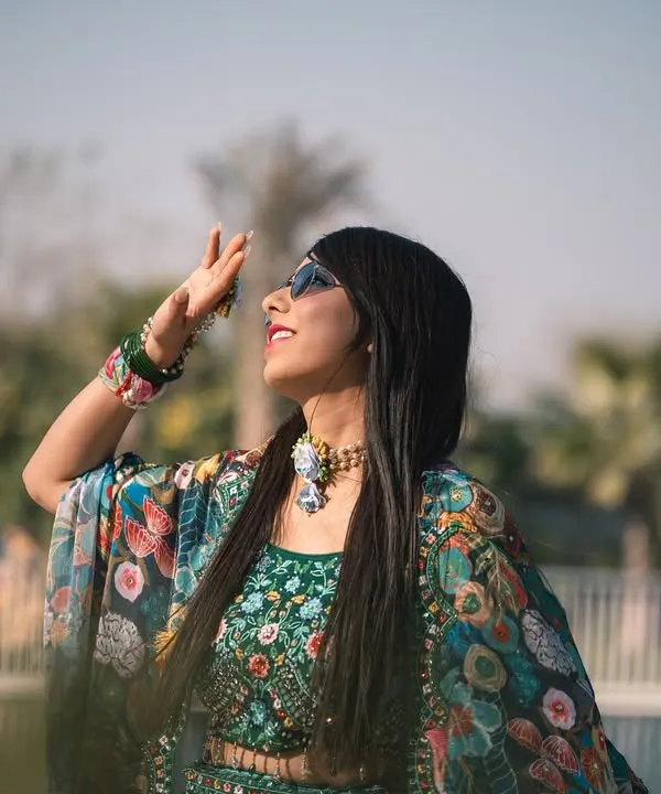 A stylish shot of the bride enjoying the sun during her outdoor Mehandi function. Her modern, colorful outfit and sunglasses give this a fun, festive vibe.