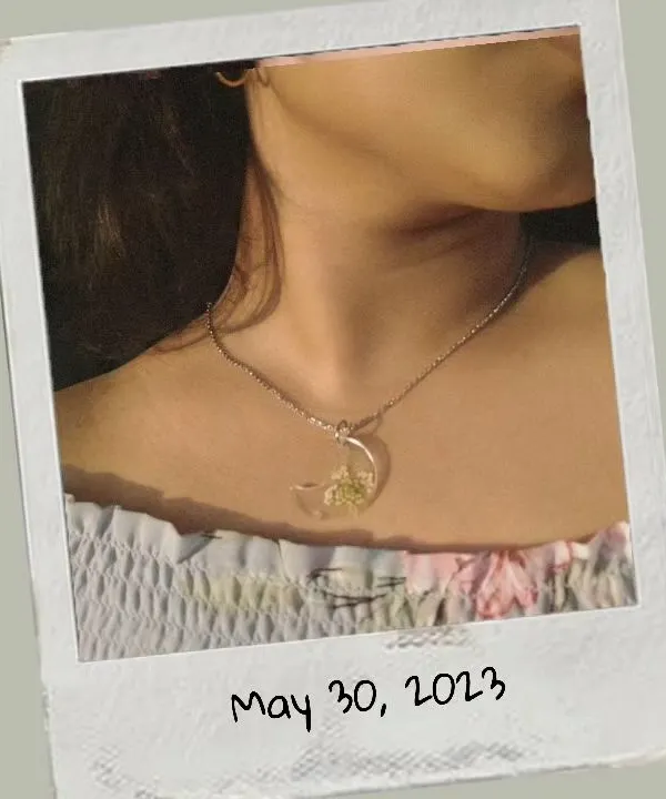 A model wearing my moon-shaped resin pendant with preserved baby's breath flowers. This shows how delicate and beautiful the necklaces look when worn.