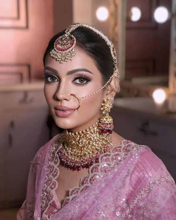 A stunning bride wearing one of my custom pink and gold kundan choker sets. The set includes a matching mathapatti, nath, and jhumkas, perfectly complementing her pink lehenga.
