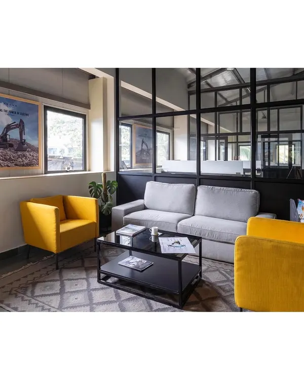 The waiting lounge in the Nagpur office facility. We used comfortable, modern furniture with pops of corporate color against a backdrop of glass and metal to create an inviting first impression.