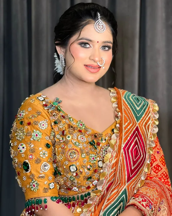 A beautiful portrait of a bride ready for her cocktail event. The makeup is soft and glowing, with a traditional maang tikka.