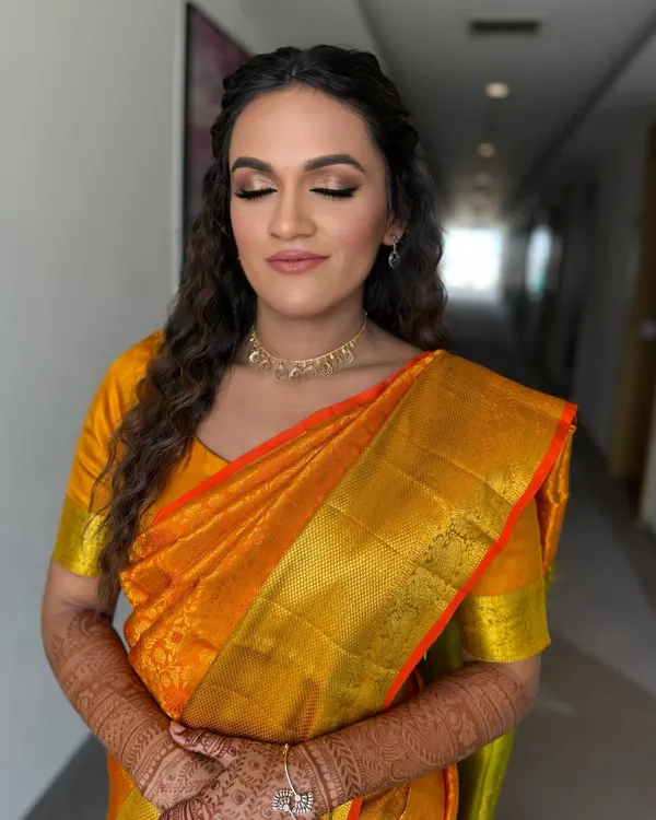 A close-up of the fresh, golden, glowing look on our beautiful bride in a Kanjivaram saree. The soft makeup and messy curls are a perfect match.