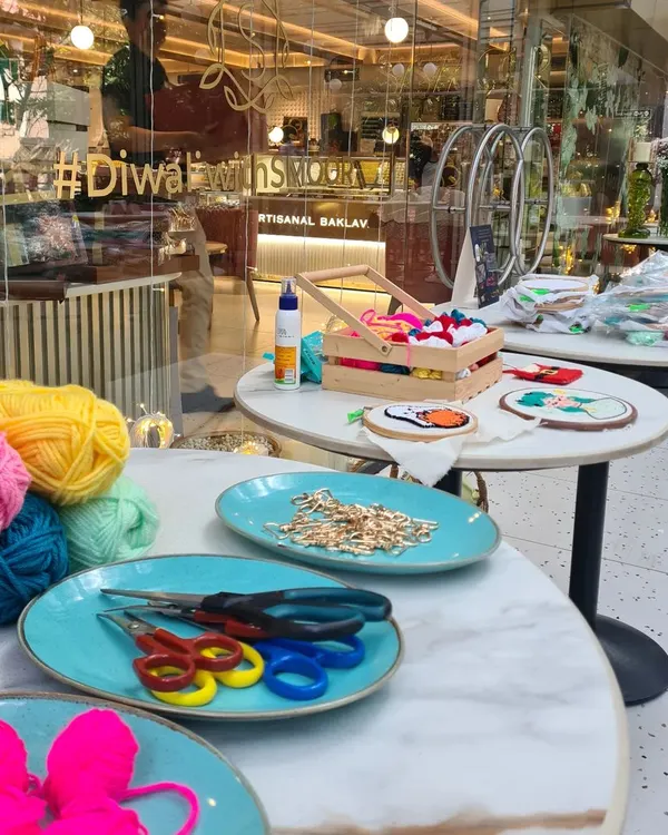 A snapshot of a workshop table, ready for creativity. I provide everything you need, from colorful balls of yarn to scissors and hoops.
