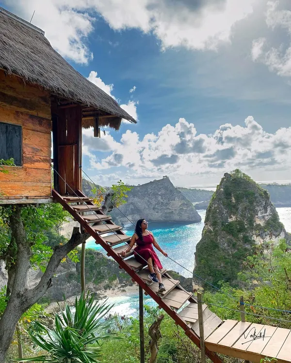 A solo portrait on the iconic treehouse stairs in Nusa Penida, Bali. I timed this shot to capture the vibrant turquoise water and dramatic clouds, turning a travel moment into a painting-like memory. This is what I mean by making your trip look like a movie.