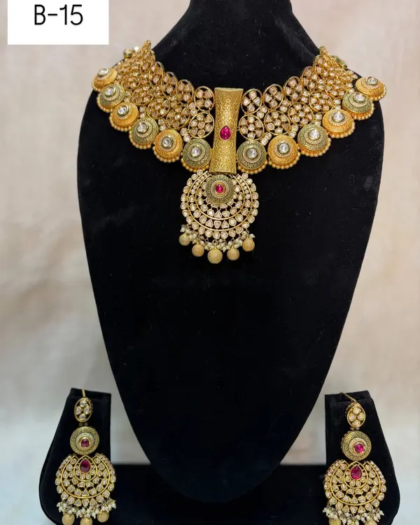 This is my bridal set B-15, which has a beautiful antique gold finish. The design features a central pendant with red stone and large, ornate matching earrings.