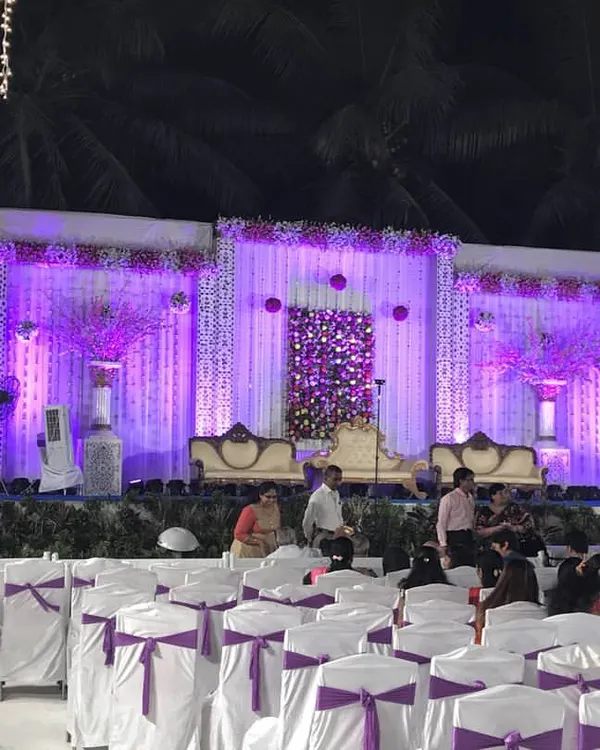 This is a complete stage and seating setup for a large evening event. I handle everything from the elegant stage backdrop and VIP sofas to the professional purple lighting and neat rows of chairs with matching covers.