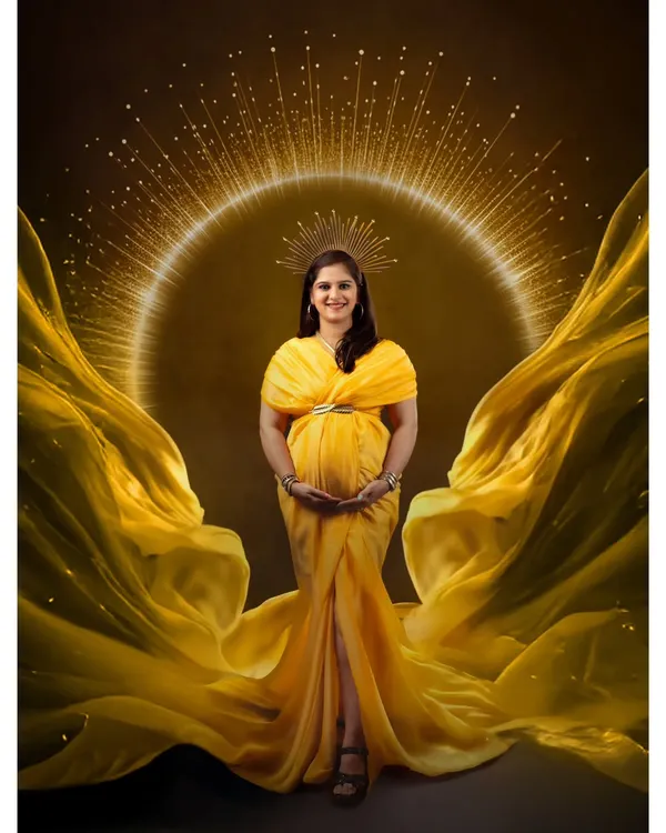 A regal portrait for a radiant mother-to-be, captured with a stunning golden halo effect and a flowing yellow gown. This is our signature queen-style maternity shoot, designed to make you feel like royalty.