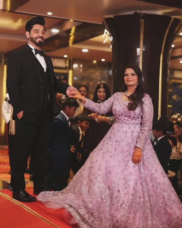Capturing the grand entrance at a reception or engagement party. The groom leads his bride onto the dance floor, her flowing lavender gown creating a beautiful sense of motion. This shot captures the excitement and fairytale quality of the evening.