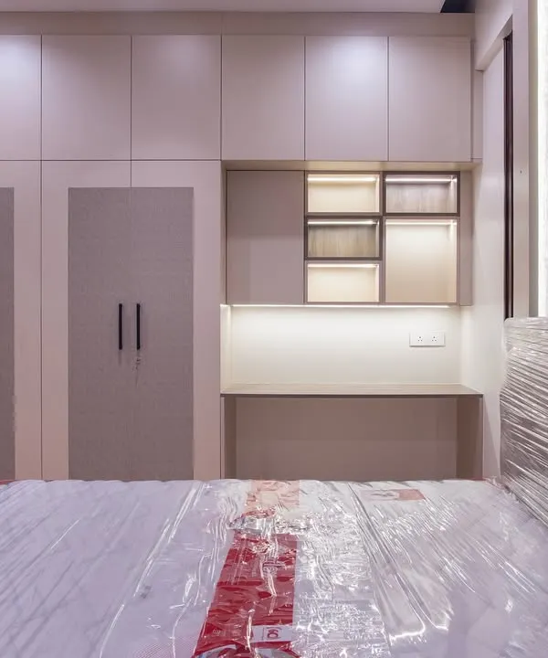 For this guest bedroom, I designed a wardrobe unit that includes an integrated desk and open shelving with backlighting. This creates a cozy, functional corner for guests to work or unwind without cluttering the room.