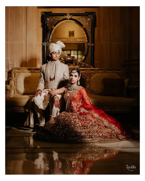 A portrait that exudes royalty. Amala and Aditya are framed by the opulent interiors of the Umaid Bhawan Palace, a perfect blend of regal attire and a majestic setting.