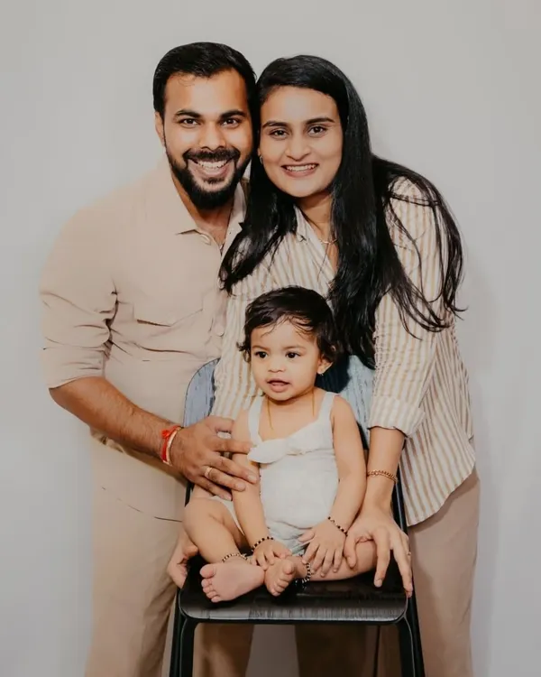 A beautiful, simple family portrait. The coordinated neutral outfits and genuine smiles make this a timeless keepsake.