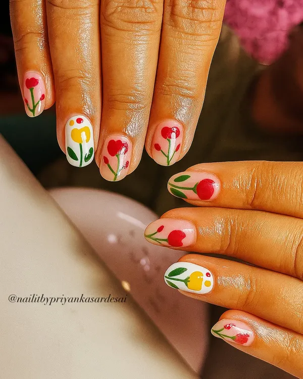 A garden party on your nails. This adorable set on short, natural nails features hand-painted red and yellow tulips against a sheer nude base for a fresh and playful look.