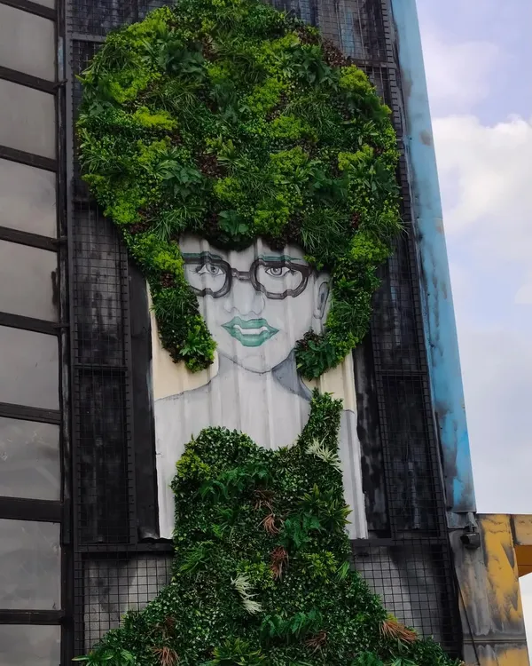 We go beyond simple green walls. This project at Bombay Adda shows our ability to create custom art murals, integrating greenery into a painted portrait to make a bold, unforgettable statement on a building's facade.