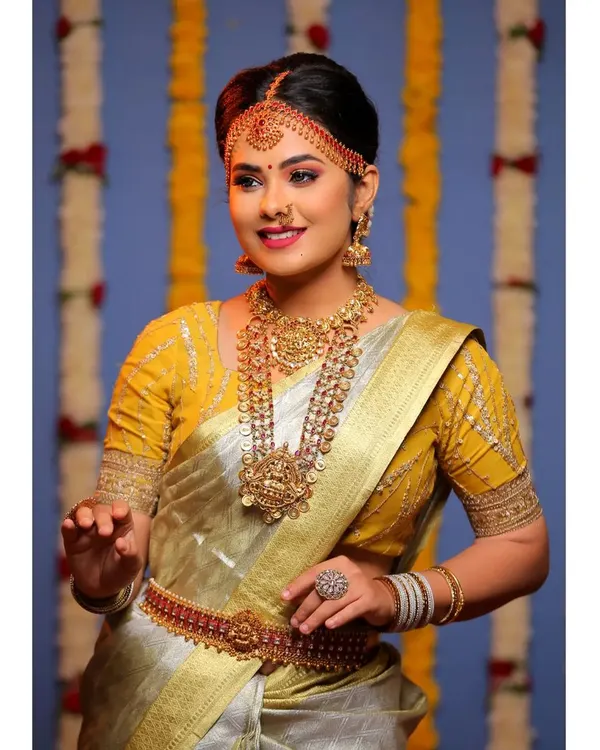 A classic South Indian bridal look for a photoshoot, featuring a beautiful tissue silk saree. I created a warm, golden look with defined eyes and traditional jewelry placement to capture the essence of our heritage.