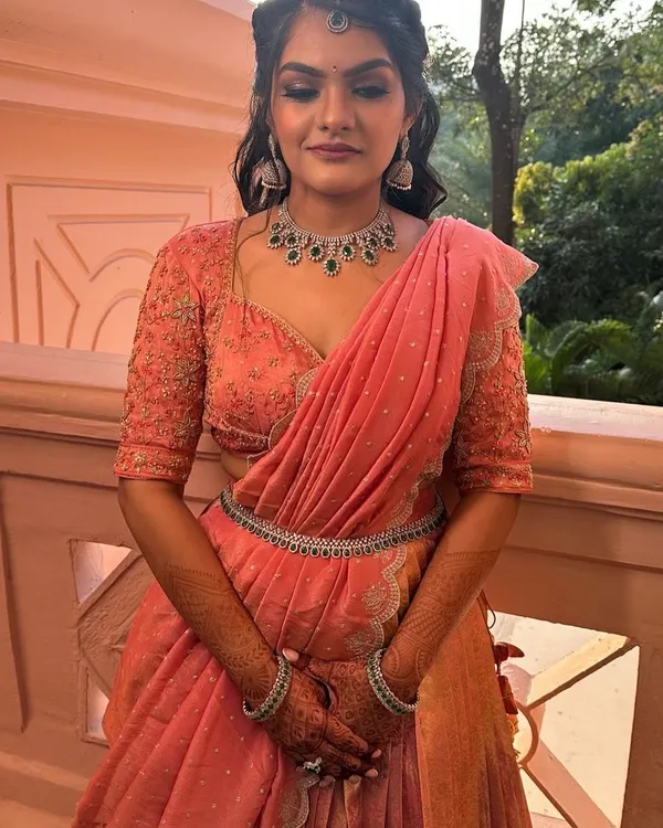 Our client looking absolutely radiant in her custom-made peach langa davani, upcycled from a Kanchi saree. The perfect outfit for a wedding celebration.