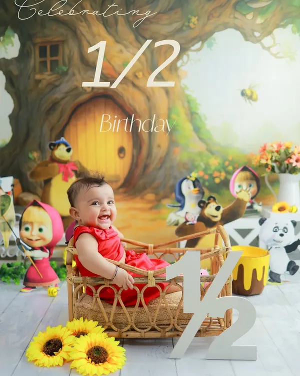 Celebrating six months of sweetness. This half-birthday shoot with a Masha and the Bear theme is full of joy and personality. The wicker basket and cartoon characters create a fun, storybook setting.