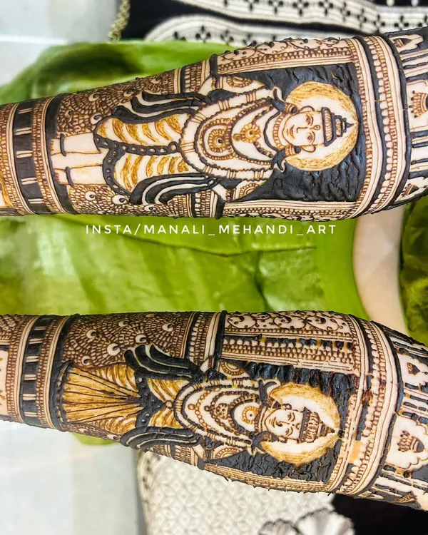 A close-up of the Lord Vitthal and Rukmini portraits from a devotional mehandi design. The dark henna application makes the divine figures stand out beautifully.