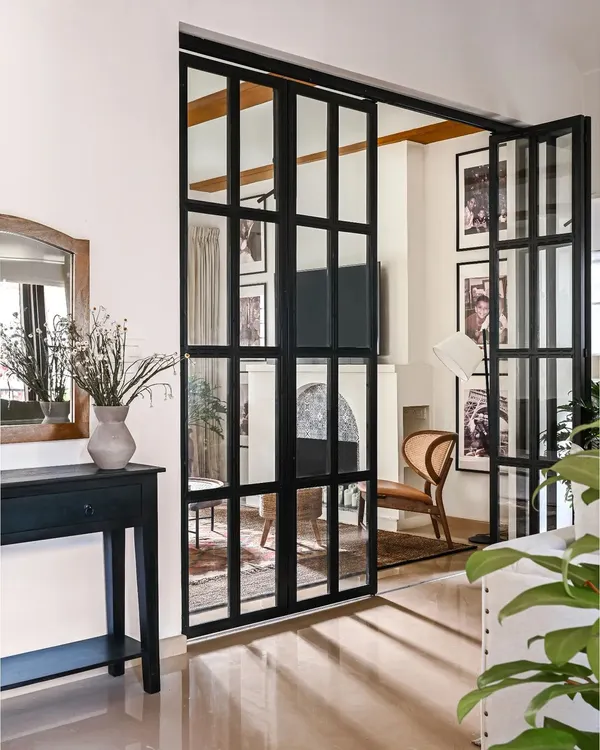The entryway of the Modern Spanish Home makes a statement from the moment you walk in. I designed these giant black iron and glass bi-fold doors to separate the living and family rooms, creating privacy without closing off the space entirely.