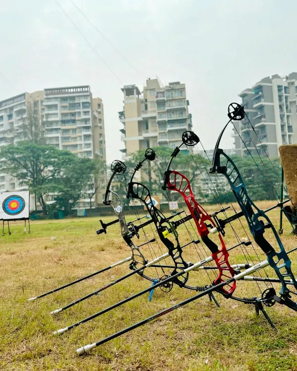 A lineup of high-performance compound bows on their stands, ready for action. We train with professional-grade equipment to prepare our archers for competition.