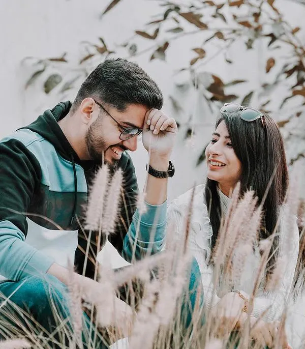 A lighthearted moment during a pre-wedding shoot where the couple shares a laugh. I used the natural foliage to frame them, creating a soft and romantic atmosphere for this candid couple portrait.