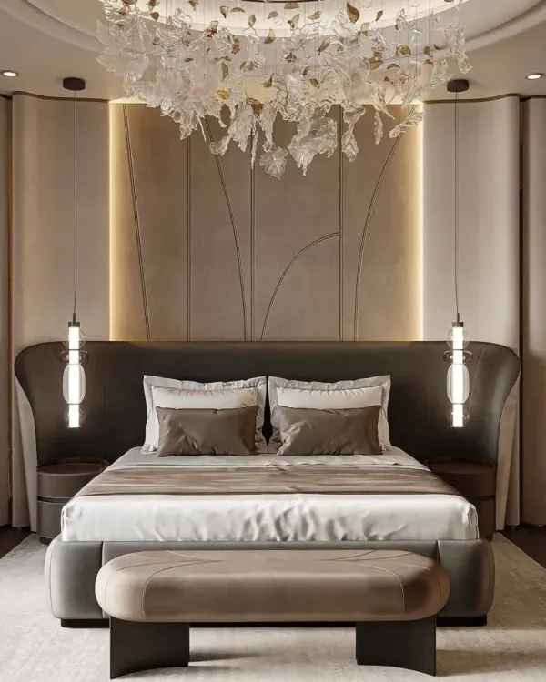 An ultra-luxurious master bedroom featuring a dramatic winged headboard, exquisite pendant lights, and a custom chandelier. This is where we turn your bedroom into a personal five-star suite.