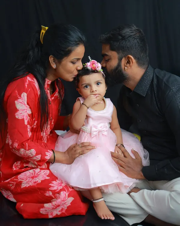 A beautiful family portrait from a first birthday session. The love and affection from both parents as they kiss their daughter is a memory that will be treasured for a lifetime.