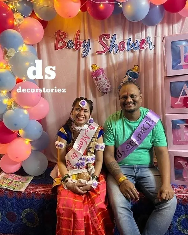 A happy couple at their baby shower celebration. I create beautiful photo backdrops like this one, complete with sashes for the 'Mom to be' and 'Dad to be'.