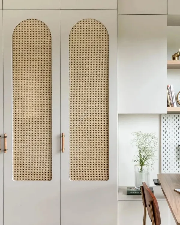Storage can be beautiful. These custom wardrobes feature arched panels with cane webbing, combining a light, natural texture with the clean lines of modern cabinetry.