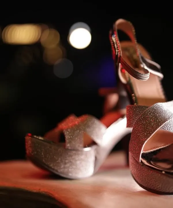 A beautifully lit, artistic shot of the bride's sparkling wedding heels, capturing the glamour and detail of her accessories.