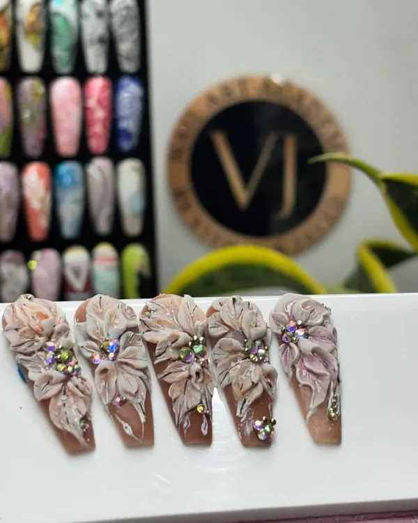 This is advanced 3D nail art. We teach our students how to sculpt these incredibly detailed, multi-layered flowers with rhinestone centers for a truly show-stopping effect.