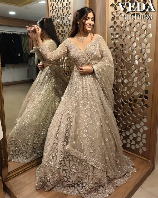 A stunning pre-loved lehenga in a sophisticated beige tone. The full-length view shows the beautiful flare and the all-over sequin and thread work, perfect for a reception.