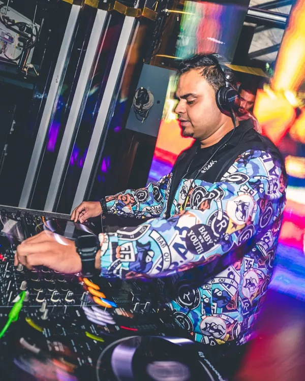 In the zone, focused on the mix. This is my office, where I blend tracks and read the energy of the room to create a seamless musical journey.