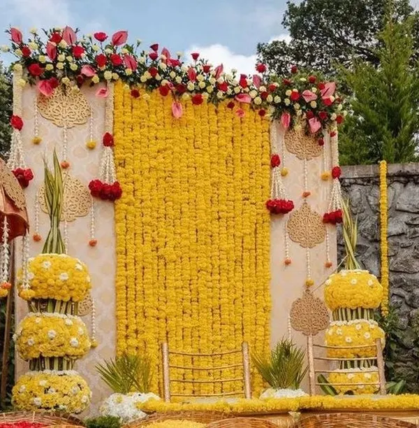 A classic haldi ceremony backdrop featuring a wall of bright yellow marigolds. I added hanging floral strings (latkans) and tiered floral stands to create a traditional and festive look, perfect for capturing the joy of the ceremony.