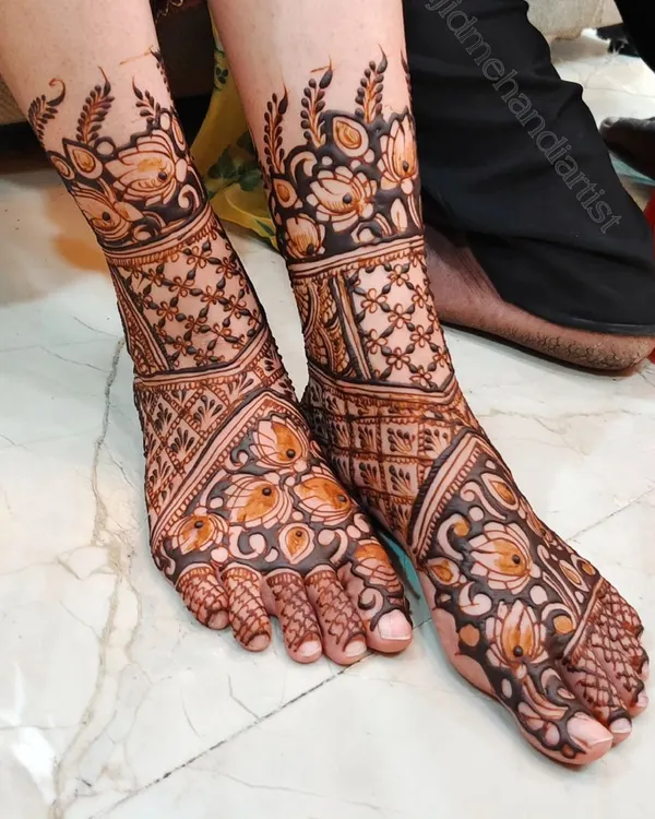 This is a classic bridal feet design, covering the entire foot with a mix of floral and jaali (net) patterns. The design is symmetrical and ensures the bride's feet look beautiful from every angle.