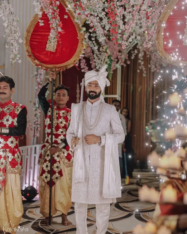 A groom's grand entrance, looking regal in his white sherwani and holding a traditional sword. We capture the groom's moments with the same importance as the bride's.