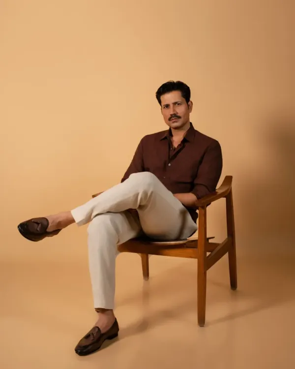 A classic seated portrait of actor Sumeet Vyas for an editorial feature. The clean background and simple chair put all the focus on his confident presence, making it a strong and effective headshot for professional use.