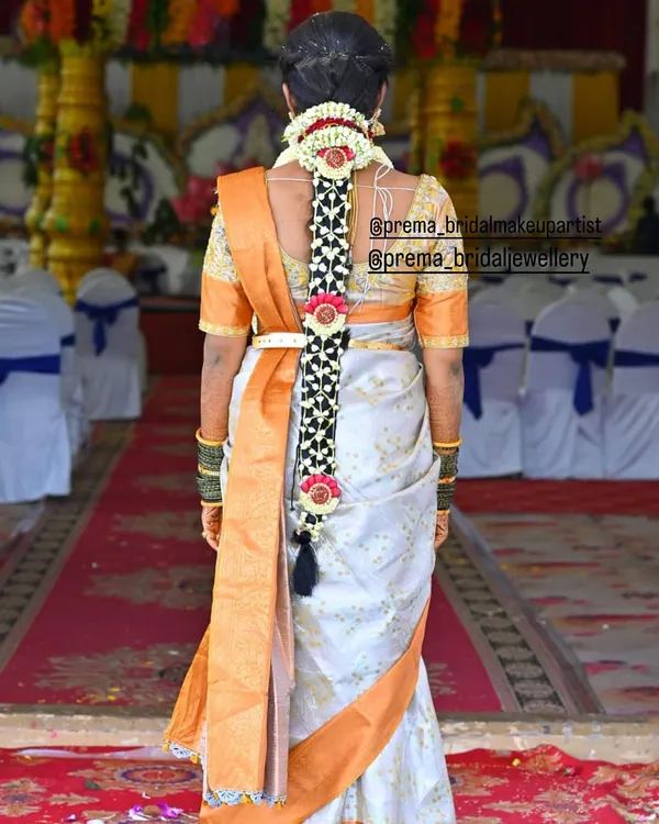A classic South Indian bridal braid, intricately woven and decorated with a traditional hair accessory. This hairstyle is elegant and timeless.