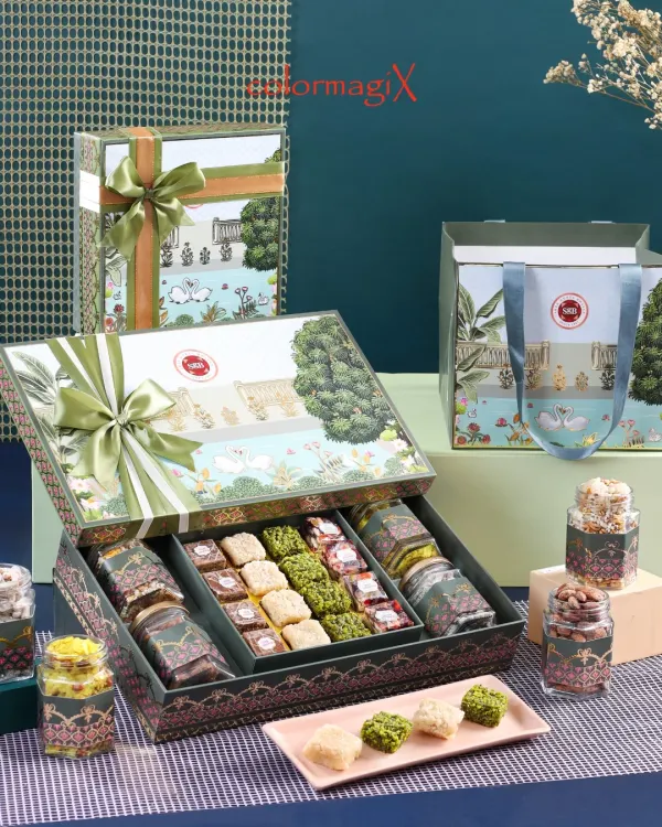 A stunning example of our multi-compartment festive hampers, featuring an assortment of traditional Indian sweets and premium dry fruits. The intricate design and high-quality materials of the box reflect our commitment to luxury.