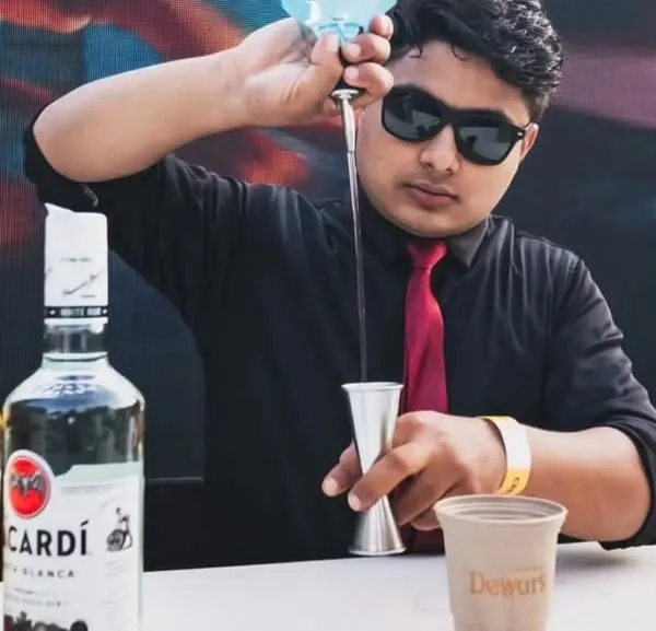 A close-up of one of our mixologists precisely measuring ingredients for a cocktail. This focus on accuracy and quality spirits like Dewar's and Bacardi is what makes our drinks consistently delicious.