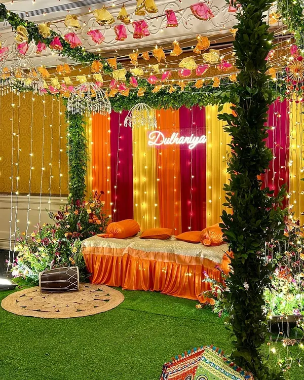 A vibrant Dholki night setup in a client's home. We used a colorful backdrop, fairy lights, a 'Dulhaniya' neon sign, and traditional elements like a dholki drum to create a fun and festive atmosphere.
