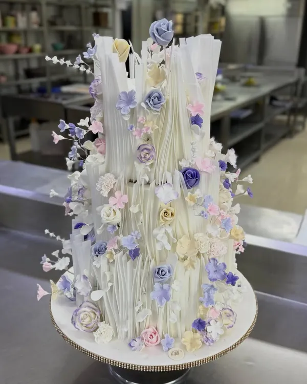 This dreamy custom cake is one of my favorites, featuring delicate wafer paper ruffles and a cascade of handmade sugar flowers in soft pastel shades. It’s a perfect example of how I can turn a simple idea into an elegant centerpiece for a wedding or engagement.