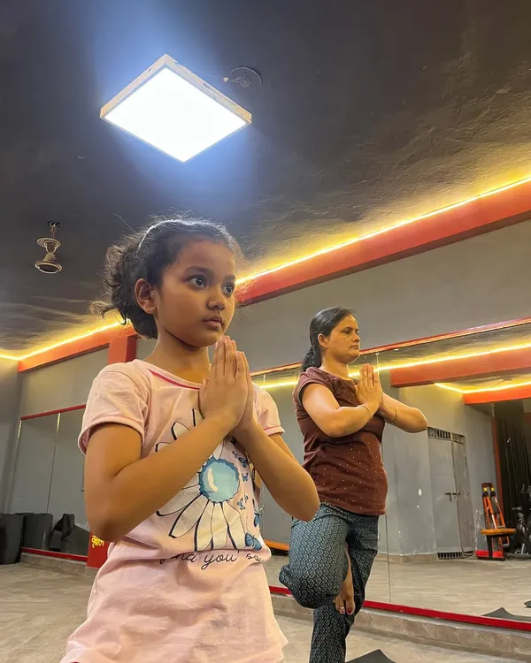 A young student learning Vrikshasana (Tree Pose). Starting yoga early is a wonderful way to build balance, focus, and body awareness.