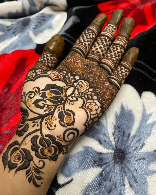 This design is a little different, using negative space to create a modern floral vine on the back of the hand. The dark henna makes the flowers and leaves stand out beautifully.