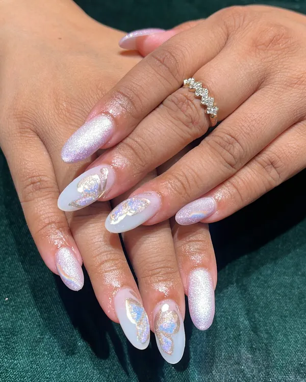 This is what we mean by nails that tell a story. This dreamy look features long almond-shaped acrylic extensions with a pearlescent base, topped with delicate, holographic butterfly art. It's a perfect example of our custom, high-end nail design.