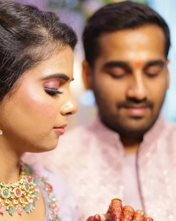 A close up of this bride's engagement makeup, focusing on a shimmery pink eyeshadow look and flawless, glowing skin. This look was created to complement her beautiful lavender lehenga and intricate jewelry for her ring ceremony.