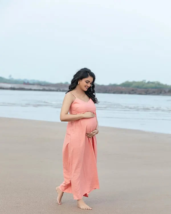 A peaceful walk along the shoreline. The soft, natural light and gentle sea breeze create a serene and beautiful setting for a maternity portrait.
